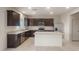 A kitchen featuring dark cabinets, stainless steel appliances, granite countertops, and tile floors at 42955 W Palo Amarillo Rd, Maricopa, AZ 85138