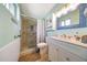 Bright bathroom featuring a tiled shower, glass door, and white vanity at 4418 W Palo Verde Ave, Glendale, AZ 85302