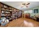 Spacious living room featuring hardwood floors, a ceiling fan, and custom built-in bookshelves at 4418 W Palo Verde Ave, Glendale, AZ 85302