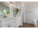 Bathroom with double sink vanity, framed mirrors, modern lighting, and wood-look flooring at 4526 E Bannock St, Phoenix, AZ 85044