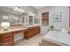Bathroom featuring a soaking tub with jets, double vanities, tile backsplash, and natural lighting at 5626 E Sleepy Ranch Rd, Cave Creek, AZ 85331