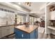 Bright kitchen featuring a blue island, white cabinetry and dining space at 5993 W Topeka Dr, Glendale, AZ 85308