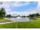 Picturesque community pond with a fountain surrounded by lush green grass and trees at 5993 W Topeka Dr, Glendale, AZ 85308