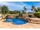 Sparkling backyard pool with rock accents, mature landscaping, and sunny patio at 5993 W Topeka Dr, Glendale, AZ 85308
