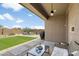 Covered patio with outdoor furniture, built-in grill, and well-manicured lawn at 6338 W Raymond St, Phoenix, AZ 85043