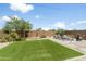 An outdoor space with healthy green lawn, trees, and outdoor seating at 6338 W Raymond St, Phoenix, AZ 85043
