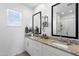 Bright bathroom features a double vanity, modern mirrors, and granite countertops at 6338 W Raymond St, Phoenix, AZ 85043