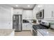 Elegant kitchen with white cabinetry, stainless steel appliances, and granite countertops for a modern feel at 6338 W Raymond St, Phoenix, AZ 85043