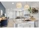Well-lit kitchen featuring a granite island, white cabinetry, stainless steel appliances, and an open floor plan at 6338 W Raymond St, Phoenix, AZ 85043