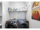 Modern laundry room with newer appliances, shelving and a clean and bright appearance at 6338 W Raymond St, Phoenix, AZ 85043