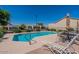 Community pool area with clear water, lounge chairs, umbrellas and surrounding landscaping at 64 N 63Rd St # 55, Mesa, AZ 85205