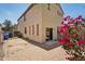 Exterior view of stucco home with paver patio, a blooming bougainvillea, and access through sliding glass door at 7501 S 14Th St, Phoenix, AZ 85042