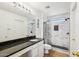 Modern bathroom showcasing a granite countertop vanity and a walk-in shower with marble-style tile at 7501 S 14Th St, Phoenix, AZ 85042
