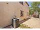 Exterior side of home with air conditioning unit, small yard area, and blooming shrubbery at 7501 S 14Th St, Phoenix, AZ 85042