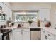 Well-lit kitchen with quartz countertops, stainless steel appliances, and a view through the window at 828 E Le Marche Ave, Phoenix, AZ 85022