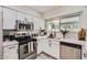 Modern kitchen featuring stainless steel appliances, white cabinetry, and a bright window over the sink at 828 E Le Marche Ave, Phoenix, AZ 85022