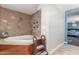 Bathroom showcases a whirlpool tub, tile surround, and convenient built-in shelves at 8464 N 7Th Ave, Phoenix, AZ 85021