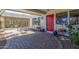 Welcoming patio features a bright red door, lovely flowers, and comfortable seating area at 8464 N 7Th Ave, Phoenix, AZ 85021