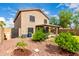 Beautiful backyard showcasing the home's exterior, lush landscaping, and a charming covered patio for outdoor living at 864 S 223Rd Ln, Buckeye, AZ 85326