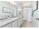 Bright bathroom with white cabinets, granite counters, and a shower-tub combination at 864 S 223Rd Ln, Buckeye, AZ 85326