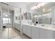 Bathroom features double sinks, a large mirror, and a sliding glass door shower, and leads to main bedroom at 864 S 223Rd Ln, Buckeye, AZ 85326