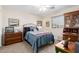 Cozy bedroom featuring a vintage bed frame, a built-in desk, and natural light from a window at 864 S 223Rd Ln, Buckeye, AZ 85326
