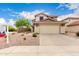Inviting two-story home with manicured desert landscaping, a wide driveway, and a two-car garage at 864 S 223Rd Ln, Buckeye, AZ 85326