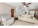 Spacious living room featuring neutral furniture, a ceiling fan, and a grandfather clock at 864 S 223Rd Ln, Buckeye, AZ 85326