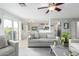 Bright living room featuring neutral tones, a ceiling fan, and a sliding glass door leading to the backyard at 864 S 223Rd Ln, Buckeye, AZ 85326