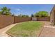 Low maintenance backyard with high block wall, storage shed and small patch of green grass at 871 E Melanie St, San Tan Valley, AZ 85140
