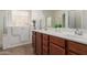 Well-lit bathroom featuring a walk-in tub, wooden cabinets, and double sinks at 871 E Melanie St, San Tan Valley, AZ 85140