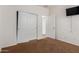 This cozy bedroom features plush carpet, a TV mount and a double-door closet at 871 E Melanie St, San Tan Valley, AZ 85140