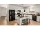 Bright kitchen with an island featuring bar seating and sleek black appliances complementing the white cabinetry at 871 E Melanie St, San Tan Valley, AZ 85140
