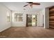 Spacious carpeted living room with a ceiling fan and backyard access through sliding glass doors at 871 E Melanie St, San Tan Valley, AZ 85140