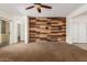 Open-concept living room featuring stylish wood accent wall and backyard access through sliding glass doors at 871 E Melanie St, San Tan Valley, AZ 85140