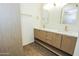 Bright bathroom featuring a double vanity, white countertops, and modern gold fixtures at 925 E Wagoner Rd, Phoenix, AZ 85022