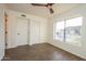 Bright bedroom featuring a ceiling fan, closet, hardwood floors, and large windows at 925 E Wagoner Rd, Phoenix, AZ 85022
