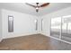 Spacious bedroom with modern ceiling fan, wood-look flooring, and natural light from several windows at 925 E Wagoner Rd, Phoenix, AZ 85022