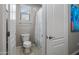 Bright bathroom with shower/tub combo and a toilet; artwork and white door, and a single window at 10071 W Angels Ln, Peoria, AZ 85383