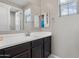 A bright bathroom features a large vanity and mirror with a view to an adjacent room with natural light at 10071 W Angels Ln, Peoria, AZ 85383