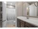 Well-lit bathroom features a vanity with dark wood cabinets, and a shower/tub combination with tile flooring at 10071 W Angels Ln, Peoria, AZ 85383