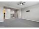 Large bonus room with neutral carpeting and a ceiling fan, perfect for entertaining and relaxing at 10071 W Angels Ln, Peoria, AZ 85383