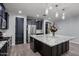 This spacious kitchen features dark cabinets, stainless appliances, a granite island, and modern lighting at 10071 W Angels Ln, Peoria, AZ 85383