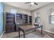Cozy office space with a large desk, built-in shelving, and natural light from the window at 10071 W Angels Ln, Peoria, AZ 85383