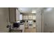 The galley kitchen is bathed in sunlight and features white cabinets and a white gas range at 10408 W Devonshire Ave, Phoenix, AZ 85037