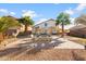 Large backyard featuring a stylish firepit, outdoor seating, and lush palm trees at 11056 W Lane Ave, Glendale, AZ 85307
