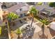Aerial view of a backyard featuring a stone fire pit, seating, desert landscaping, and mature palm trees at 11056 W Lane Ave, Glendale, AZ 85307
