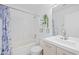 Bright bathroom with white tiled shower-tub, modern vanity, and decorative shelves at 11056 W Lane Ave, Glendale, AZ 85307