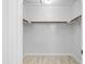 Empty walk-in closet with wood flooring and wood rods for ample storage space at 11056 W Lane Ave, Glendale, AZ 85307