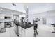 Bright modern kitchen with stainless steel appliances, island with bar seating and light tile flooring at 11056 W Lane Ave, Glendale, AZ 85307